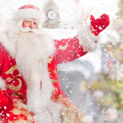 Santa sitting at the Christmas tree, near fireplace and looking 