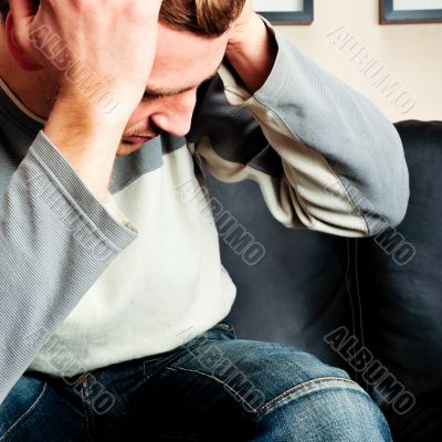 Closeup portrait of young man sitting on sofa 