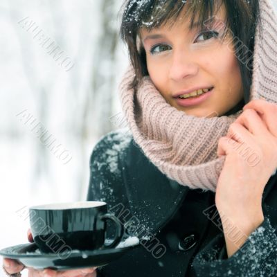 Portrait of young beautiful woman standing alone in winter park 