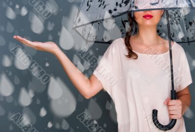 Portrait of beautiful young fashionable woman standing under umb