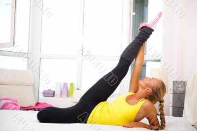 Portrait of beautiful young woman doing exercise at her home