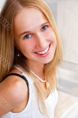 Portrait of beautiful relaxed young woman standing at the kitche