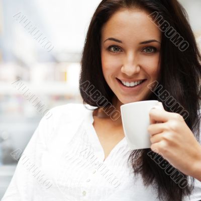 Closeup portrait of a pretty young female having a cup of coffee