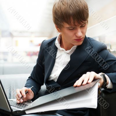 Portrait of handsome young man working with laptop at cafe at bu