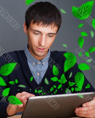 Portrait of young man sitting indoors at his office and working.