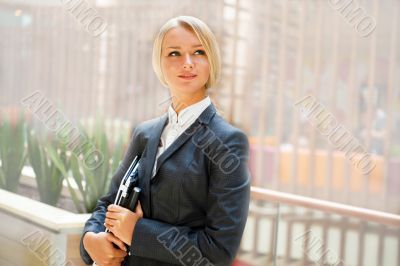Portrait of a cute business woman with her laptop inside office 