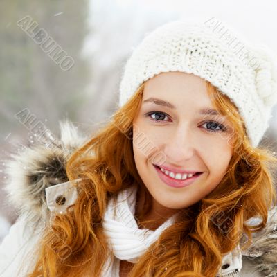 Portrait of young pretty woman in winter park