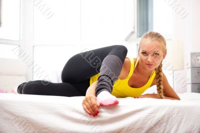 Portrait of beautiful young woman doing exercise at her home