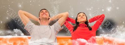 Smiling beautiful couple sitting on a sofa at their apartment an