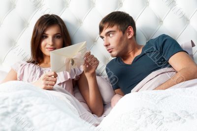 Closeup portrait of a happy young couple relaxing on the bed. Ma