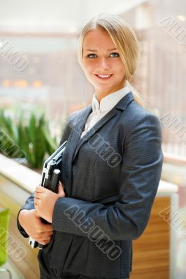Portrait of a cute business woman with her laptop inside office 