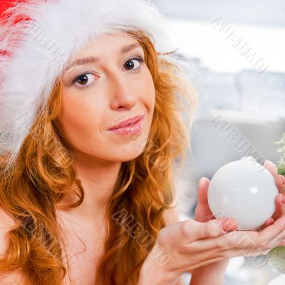Christmas woman near a Christmas tree holding Christmas toy whil