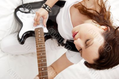Portrait of beautiful young and attractive womanplaying her guit