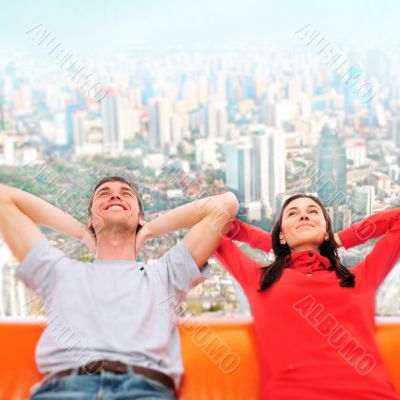 Closeup portrait of adult couple sitting on their sofa against b