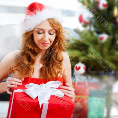 Christmas woman near a Christmas tree holding big gift box while