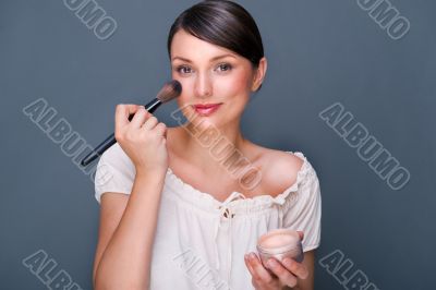 Portrait of a Beautiful woman with makeup brush near her face lo