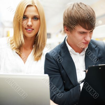Two students working on their college project at hall using lapt