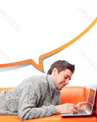 Portrait of young handsome student man laying on sofa using lapt