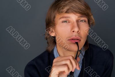 Portrait of a handsome young business man leaning against the wa
