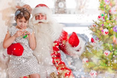 Christmas theme: Santa Claus and little girl having a fun. Indoo