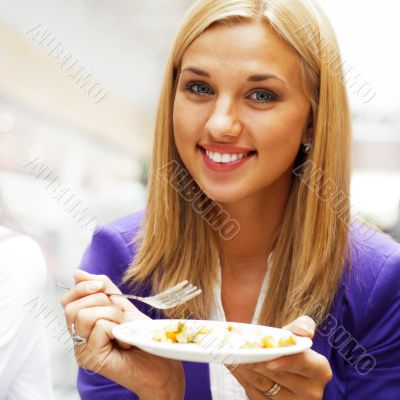 Closeup portrait of an attractive young woman eating fruit salad