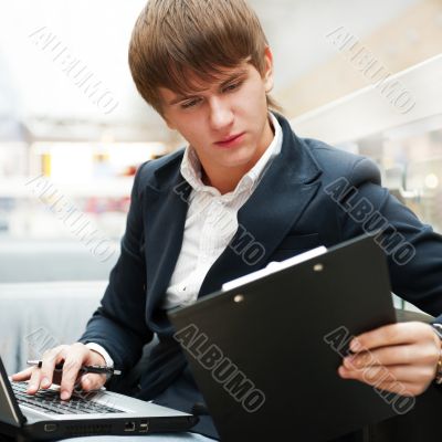 Portrait of handsome young man working with laptop at cafe at bu