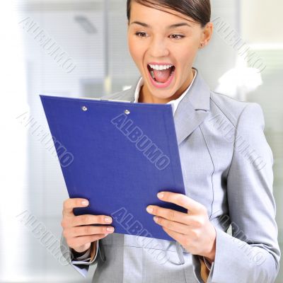 Portrait if young business woman at her office holding report