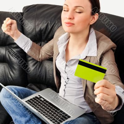 Portrait of a young woman lying on the couch and shopping from t