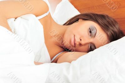 Fashion portrait of young elegant woman in bed