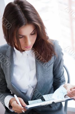 Portrait of an adorable business woman working at her desk with 