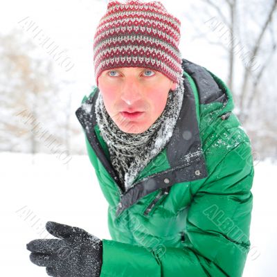 Closeup portrait of young man running in winter park