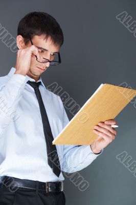 Closeup of a young smiling business man standing confidently aga