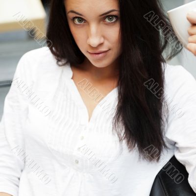 Closeup portrait of a pretty young female having a cup of coffee