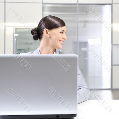 Young business woman on a laptop at her office. Looking Away