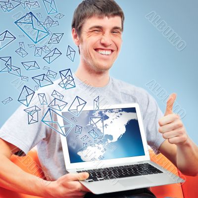 Portrait of handsome young man holding laptop computer and worki