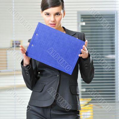 A portrait of a young business woman in an office with documents