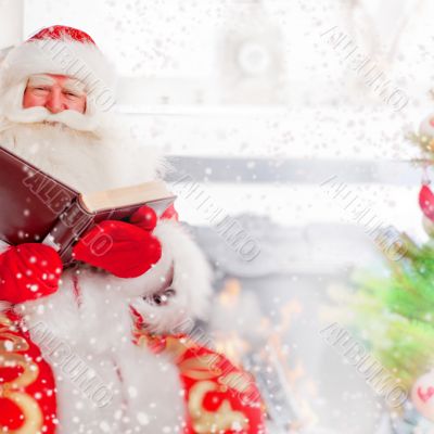 Santa sitting at the Christmas tree, near fireplace and reading 