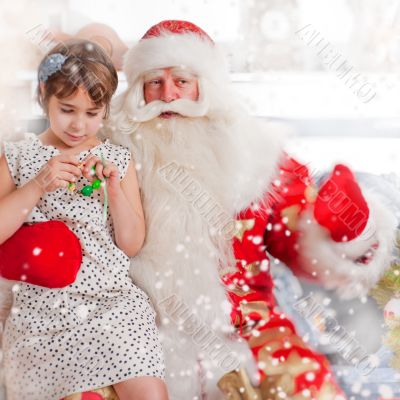Christmas theme: Santa Claus and little girl having a fun. Indoo