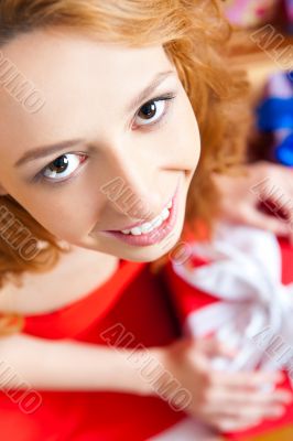 Christmas woman near a Christmas tree holding big gift box while