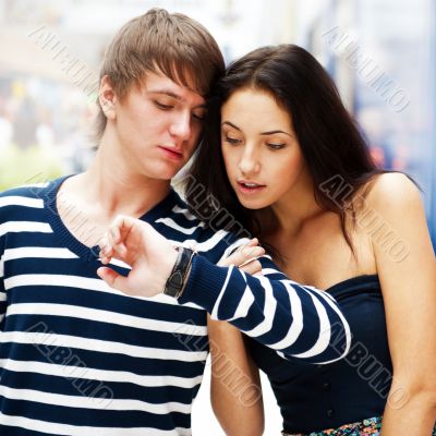 Portrait of young couple standing together at airport hall and l