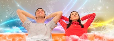 Smiling beautiful couple sitting on a sofa at their apartment an
