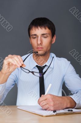 Portrait of an adult business man sitting in the office and sign
