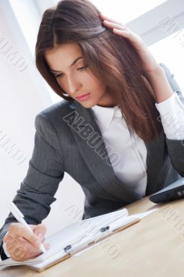Portrait of an adorable business woman working at her desk with 