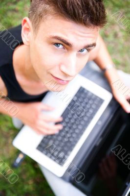 Closeup portrait of young student man using laptop and 3g usb mo