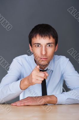 Portrait of aconfident young business man in suit pointing at yo