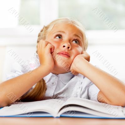 Portrait of a young girl in school at the desk.
