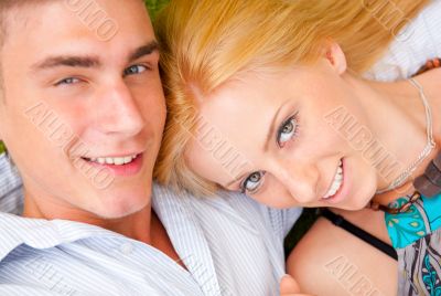 A happy young couple lying on grass