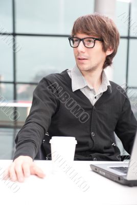 Friendly executive sitting in front of laptop