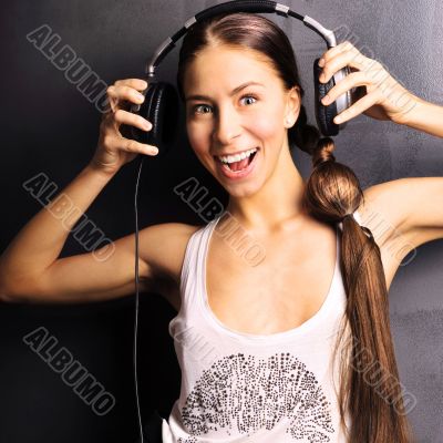Club style woman with headphones listening to music