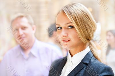Portrait of a cute business woman with colleagues at the backgro